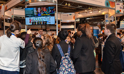 school students trying the nuclear reactor simulator game at a fair